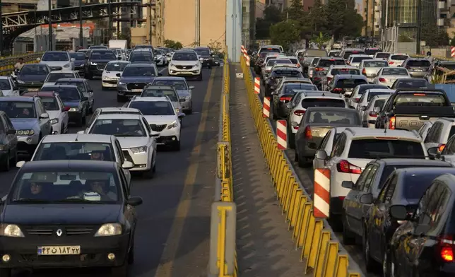 People commute in their cars during an afternoon traffic jam in northern Tehran, Iran, Tuesday, July 2, 2024. Comments suggesting that Iran's reformist presidential candidate could increase government-set gasoline prices have raised fears of a repeat of nationwide protests. (AP Photo/Vahid Salemi)