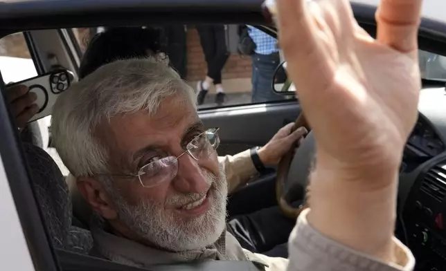 Candidate for the presidential election Saeed Jalili, a former Iranian top nuclear negotiator, waves while leaving after the conclusion of a meeting with his athlete supporters, in Tehran, Iran, Sunday, June 30, 2024. Comments suggesting that Iran's reformist presidential candidate could increase government-set gasoline prices have raised fears of a repeat of nationwide protests. (AP Photo/Vahid Salemi)