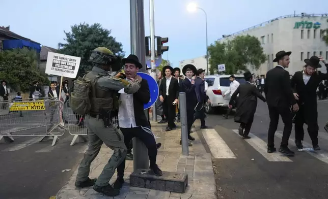Ultra-Orthodox Jewish men clash with police during a rally against army recruitment in Jerusalem on Sunday, June 30, 2024. Israel's Supreme Court last week ordered the government to begin drafting ultra-Orthodox men into the army, a landmark ruling seeking to end a system that has allowed them to avoid enlistment into compulsory military service. (AP Photo/Ohad Zwigenberg)
