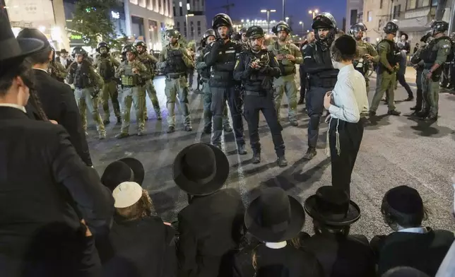 Ultra-Orthodox Jewish men clash with police during a rally against army recruitment in Jerusalem on Sunday, June 30, 2024. Israel's Supreme Court last week ordered the government to begin drafting ultra-Orthodox men into the army, a landmark ruling seeking to end a system that has allowed them to avoid enlistment into compulsory military service. (AP Photo/Mahmoud Illean)