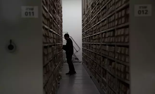 A worker peruses the documents archive at The Moshal Shoah Legacy Campus and The David and Fela Shapell Family Collections Center, at Yad Vashem World Holocaust Remembrance Center in Jerusalem, Monday, July 8, 2024. Israel's national Holocaust museum opened a new conservation facility in Jerusalem, which will preserve, restore, and store the more than 45,000 artifacts and works of art in a vast new building, including five floors of underground storage. (AP Photo/Maya Alleruzzo)