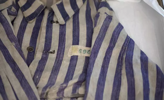 A striped uniform worn by a concentration camp prisoner is displayed in a textiles conservation lab during the inauguration of The Moshal Shoah Legacy Campus and The David and Fela Shapell Family Collections Center, at Yad Vashem World Holocaust Remembrance Center in Jerusalem, Monday, July 8, 2024. Israel's national Holocaust museum opened a new conservation facility in Jerusalem, which will preserve, restore, and store the more than 45,000 artifacts and works of art in a vast new building, including five floors of underground storage. (AP Photo/Maya Alleruzzo)