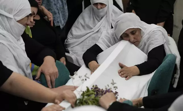 Members of the Druze minority mourn during the funeral of their relatives at the village of Majdal Shams in the Israeli-controlled Golan Heights, Sunday, July 28, 2024. A rocket strike at a soccer field in the village has killed at least 11 children and teens. It's the deadliest strike on an Israeli target along the country's northern border since the fighting between Israel and the Lebanese militant group Hezbollah began. (AP Photo/Leo Correa)