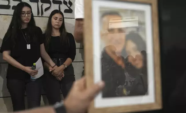 Freed Israeli hostage Noa Argamani, left, attends the funeral for wife and mother Liora Argamani, in Beersheba, Israel, Tuesday, July 2, 2024. Liora Argamani, 61, who had stage four brain cancer, had pleaded for the release of her daughter, Noa, saying she wanted to see her only child before she died. (AP Photo/Tsafrir Abayov)