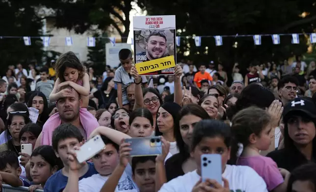 Friends and relatives welcome Almog Meir Jan, 22, who was rescued from captivity after being held hostage for nearly eight months by Hamas, as he returns from a rehabilitation center to his home in Or Yehuda, Israel, Sunday, July 7, 2024. Meir Jan was kidnapped from Israel in a Hamas-led attack on Oct. 7, 2023, and is one of four hostages who were rescued by Israeli forces on June 8. (AP Photo/Ohad Zwigenberg)