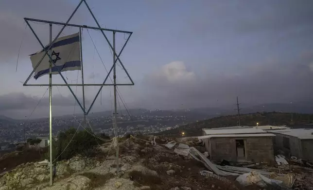 The Eviatar outpost is seen in the Israeli-occupied West Bank during morning prayers calling for the legalization of the outpost and the return of the hostages held in the Gaza Strip by the Hamas militant group, Sunday, July 7, 2024. Far-right ministers in Israel’s government have said they want to legalize unauthorized outposts in the West Bank in a sweeping expansion of settlements. (AP Photo/Ohad Zwigenberg)