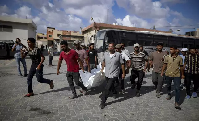 Palestinians carry the body of a person killed by Israeli bombardment in Khan Younis, southern Gaza Strip, Saturday, July 6, 2024. (AP Photo/Jehad Alshrafi)