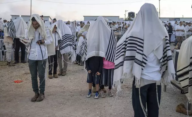 Jewish settlers pray in the Eviatar outpost in the Israeli-occupied West Bank during morning prayers calling for the legalization of the outpost and the return of the hostages held in the Gaza Strip by the Hamas militant group, Sunday, July 7, 2024. Far-right ministers in Israel’s government have said they want to legalize unauthorized outposts in the West Bank in a sweeping expansion of settlements. (AP Photo/Ohad Zwigenberg)