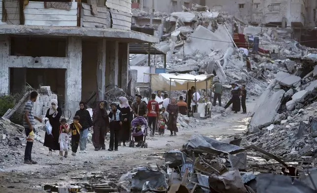 FILE - Palestinians displaced by the Israeli air and ground offensive on the Gaza Strip walk next to sewage flowing into the streets of the southern town of Khan Younis, Gaza Strip, July 4, 2024. Hamas has given initial approval for a U.S.-backed proposal for a phased cease-fire deal in Gaza, dropping a key demand that Israel gives an up-front commitment for a complete end to the war, a Hamas and an Egyptian official said Saturday July 6, 2024. (AP Photo/Jehad Alshrafi, File)