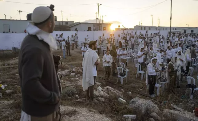 Jewish settlers pray in the Eviatar outpost in the Israeli-occupied West Bank during morning prayers calling for the legalization of the outpost and the return of the hostages held in the Gaza Strip by the Hamas militant group, Sunday, July 7, 2024. Far-right ministers in Israel’s government have said they want to legalize unauthorized outposts in the West Bank in a sweeping expansion of settlements. (AP Photo/Ohad Zwigenberg)