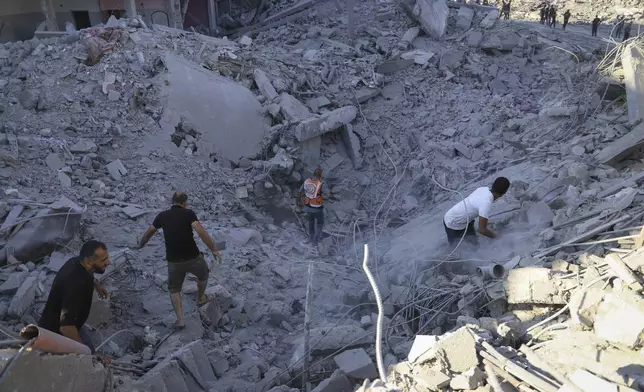 Palestinians search for bodies and survivors in the rubble of a residential building destroyed in an Israeli airstrike in Khan Younis, Gaza Strip, Wednesday, July 3, 2024. (AP Photo /Jehad Alshrafi)