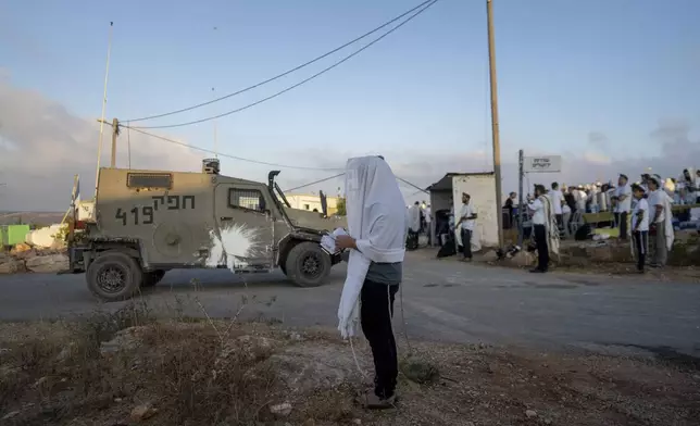 Jewish settlers pray in the Eviatar outpost in the Israeli-occupied West Bank during morning prayers calling for the legalization of the outpost and the return of the hostages held in the Gaza Strip by the Hamas militant group, Sunday, July 7, 2024. Far-right ministers in Israel’s government have said they want to legalize unauthorized outposts in the West Bank in a sweeping expansion of settlements. (AP Photo/Ohad Zwigenberg)