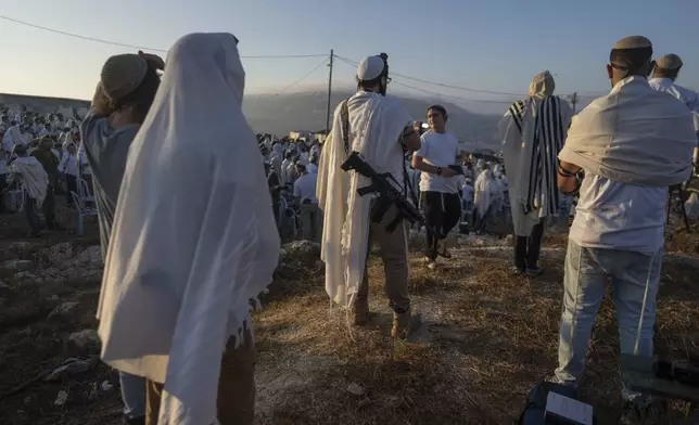 Jewish settlers pray in the Eviatar outpost in the Israeli-occupied West Bank during morning prayers calling for the legalization of the outpost and the return of the hostages held in the Gaza Strip by the Hamas militant group, Sunday, July 7, 2024. Far-right ministers in Israel’s government have said they want to legalize unauthorized outposts in the West Bank in a sweeping expansion of settlements. (AP Photo/Ohad Zwigenberg)