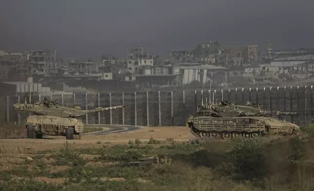 Israeli tanks stand near the Israel-Gaza border as seen from southern Israel Sunday, July 14, 2024. (AP Photo/Tsafrir Abayov)