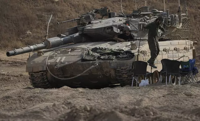 An Israeli soldier jumps from the top of a tank in an area near the Israeli-Gaza border, seen from southern Israel, Wednesday, July 24, 2024. (AP Photo/Tsafrir Abayov)