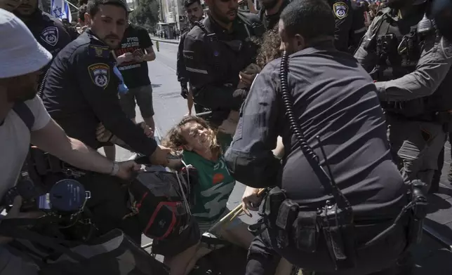 Police disperse demonstrators blocking a road during a protest calling for the release of hostages held in the Gaza Strip by the Hamas militant group, in Jerusalem, Sunday, July 7, 2024. (AP Photo/Mahmoud Illean)