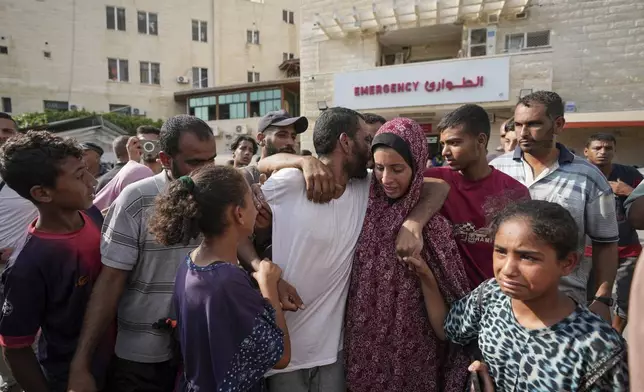 A Palestinian man, center, who was arrested in the Gaza Strip by the Israeli military and released through the Kissufim crossing point is welcomed by relatives at a hospital in Deir al Balah, central Gaza Strip on Monday, July 1, 2024. (AP Photo/Abdel Kareem Hana)