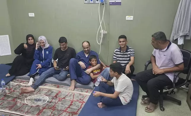This video grab shows Mohammed Abu Selmia, center, the director of Gaza's main hospital, who was detained by Israeli forces in November, sitting with his family after his release, along with other detainees, at a hospital in Khan Younis, Gaza Strip on Monday, July 1, 2024. Israel released the director of Gaza's main hospital on Monday after holding him for seven months without charge or trial over allegations the facility had been used as a Hamas command center. He said he and other detainees were held under harsh conditions and tortured. (AP Photo/Mohammad Jahjouh)