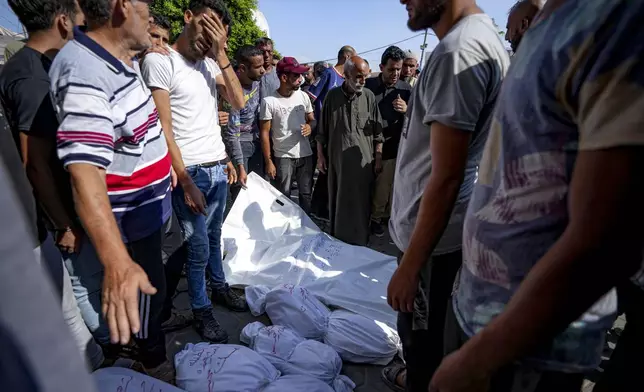 Palestinians gather near the bodies of their relatives killed in the Israeli bombardment of the Gaza Strip, at a hospital in Deir al-Balah, Thursday, July 18, 2024. (AP Photo/Abdel Kareem Hana)