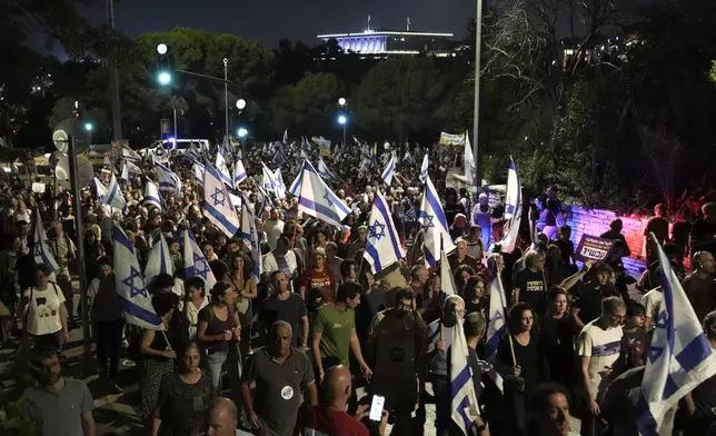 Demonstrators march with Israeli flags during a protest marking nine months since the start of the war and calling for the release of hostages held in the Gaza Strip by the Hamas militant group, in Jerusalem, Sunday, July 7, 2024. (AP Photo/Mahmoud Illean)