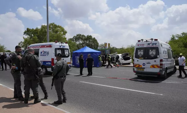 Israeli security forces examine the scene of a suspected ramming attack near Ramla, Israel Sunday, July 14, 2024. According to the authorities a car slammed into pedestrians waiting at a bus stop, leaving at least four injured people. The suspect of the attack was shot and killed while still in his car. (AP Photo/Ohad Zwigenberg)