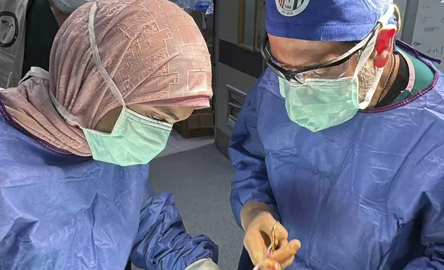 This handout photo taken on May 12, 2023 shows Dr. Adam Hamawy, right, a former U.S. Army combat plastic surgeon who volunteered in Gaza in May performing surgery on mangled hand from a blast injury at the European General Hospital, in Khan Younis, Gaza. (Adam Hamawy via AP)