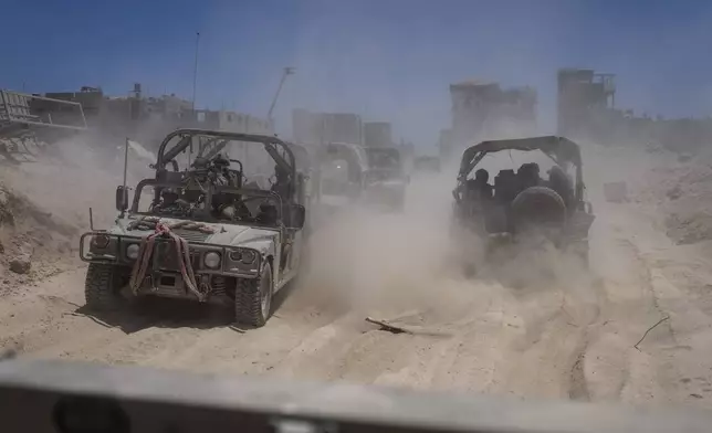 Israeli army vehicles transport a group of soldiers and journalists inside the southern Gaza Strip, Wednesday, July 3, 2024. The Israeli military invited reporters for a tour of Rafah, where the military has been operating since May 6. (AP Photo/Ohad Zwigenberg, Pool)