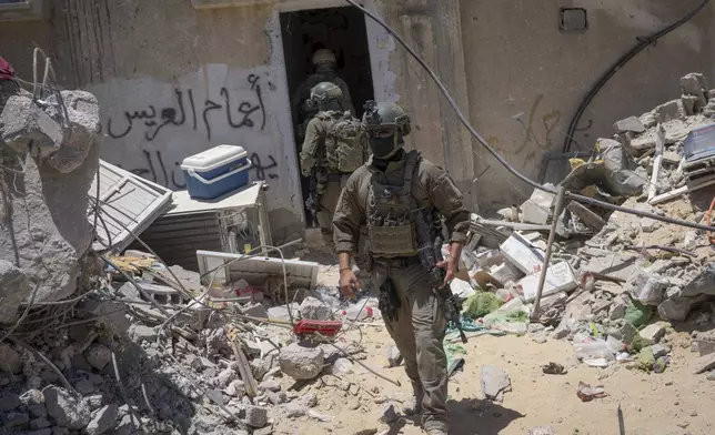 Israeli soldiers walk in the southern Gaza Strip, Wednesday, July 3, 2024. The Israeli military invited reporters for a tour of Rafah, where the military has been operating since May 6. (AP Photo/Ohad Zwigenberg, Pool)