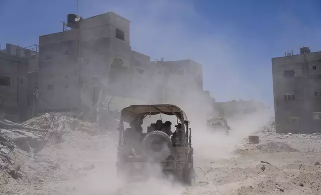 Israeli army vehicles transport a group of soldiers and journalists inside the southern Gaza Strip, Wednesday, July 3, 2024. The Israeli military invited reporters for a tour of Rafah, where the military has been operating since May 6. (AP Photo/Ohad Zwigenberg, Pool)