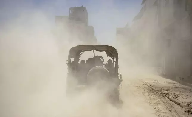 Israeli army vehicles transport a group of soldiers and journalists inside the southern Gaza Strip, Wednesday, July 3, 2024. The Israeli military invited reporters for a tour of Rafah, where the military has been operating since May 6. (AP Photo/Ohad Zwigenberg, Pool)