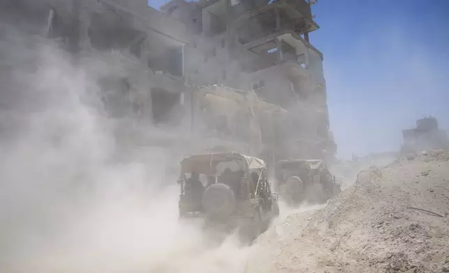 Israeli army vehicles transport a group of soldiers and journalists inside the southern Gaza Strip, Wednesday, July 3, 2024. The Israeli military invited reporters for a tour of Rafah, where the military has been operating since May 6. (AP Photo/Ohad Zwigenberg, Pool)