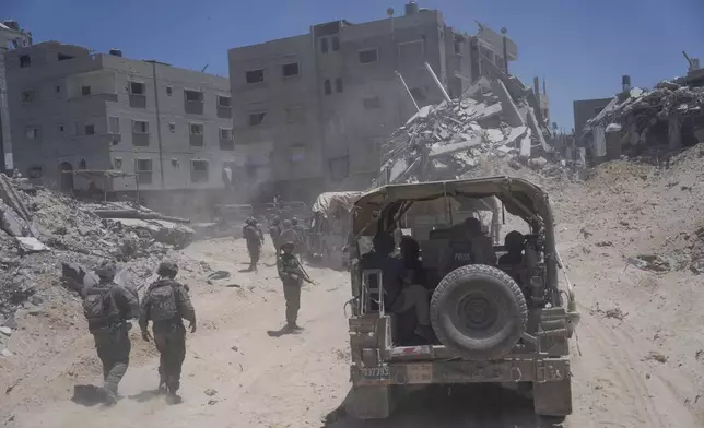 Israeli soldiers walk in the southern Gaza Strip, Wednesday, July 3, 2024. The Israeli military invited reporters for a tour of Rafah, where the military has been operating since May 6. (AP Photo/Ohad Zwigenberg, Pool)