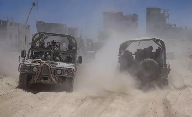 Israeli army vehicles transport a group of soldiers and journalists inside the southern Gaza Strip, Wednesday, July 3, 2024. The Israeli military invited reporters for a tour of Rafah, where the military has been operating since May 6. (AP Photo/Ohad Zwigenberg, Pool)