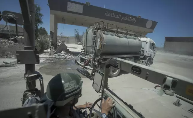 An Israeli soldier drives on the Gaza side of the Kerem Shalom crossing between Israel and the Gaza Strip, Wednesday, July 3, 2024. The Israeli military invited reporters for a tour of Rafah, where the military has been operating since May 6. (AP Photo/Ohad Zwigenberg, Pool)