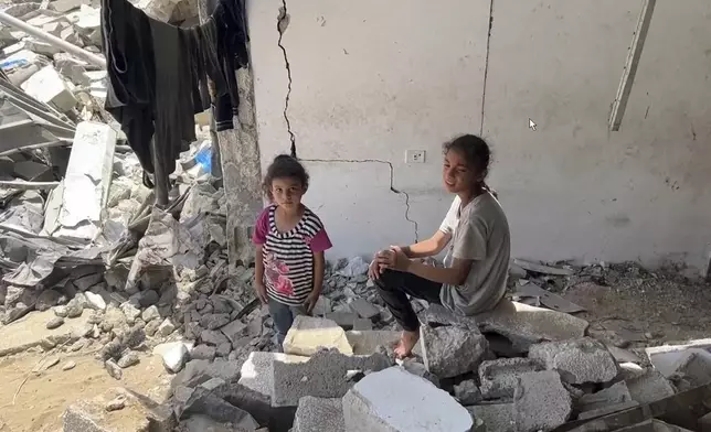 This image from video shows children sitting amongst rubble in Yarmouk Sports Stadium Friday, July 5, 2024 in Gaza City, Gaza Strip. Yarmouk Sports Stadium, once Gaza's biggest soccer arena, is now sheltering thousands of displaced Palestinians who are scraping by with little food or water. (AP Photo)