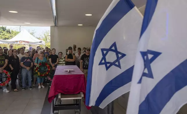 Family and friends of Yevgeny Ferde attend his funeral at a cemetery in Rishon Lezion, Israel, on Sunday, July 21, 2024. Yevgeny Ferde was killed in central Tel Aviv by an explosive drone launched by the Yemeni Houthi militant group. (AP Photo/Ohad Zwigenberg)