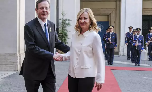 Italy's Prime Minister Giorgia Meloni, right, and Israel's President Isaac Herzog, left, shake hands during a meeting in Rome, Italy, Thursday, July 25, 2024. (Mauro Scrobogna/LaPresse via AP)