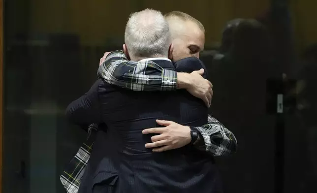 Ethan Elder, left, father of Finnegan Lee Elder hugs his son before the reading of the judgment at the end of a hearing for the appeals trial in which Finnegan is facing murder charges for killing Italian Carabinieri paramilitary police officer Mario Cerciello Rega, in Rome, Wednesday, July 3, 2024. (AP Photo/Alessandra Tarantino)