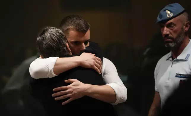 Gabriel Natale Hjorth is hugged by his father Fabrizio Natale, after the reading of the judgment at the end of a hearing for the appeals trial in which he is facing murder charges for killing Italian Carabinieri paramilitary police officer Mario Cerciello Rega, in Rome, Wednesday, July 3, 2024. (AP Photo/ Alessandra Tarantino)