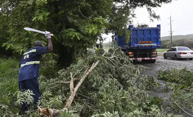 Workers remove trees branches felled by Hurricane Beryl in Kingston, Jamaica, Thursday, July 4, 2024. What had been the earliest storm to develop into a Category 5 hurricane in the Atlantic, weakened to a Category 3 by early Thursday but remained a major hurricane taking aim at Mexico’s Caribbean coast. (AP Photo/Collin Reid)