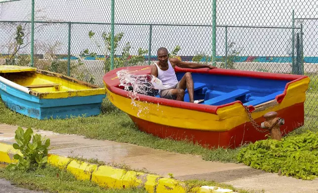 A man bails water out of his boat in the aftermath of Hurricane Beryl, in Kingston, Jamaica, Thursday, July 4, 2024. (AP Photo/Leo Hudson)