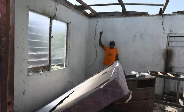 A man shows the destroyed roof of his home from Hurricane Beryl in the fishing settlement of Rocky Point, Clarendon, Jamaica, Thursday, July 4, 2024. (AP Photo/Collin Reid)