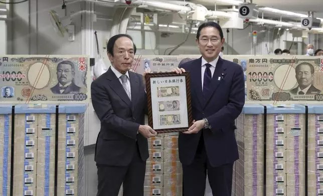 Japanese Prime Minister Fumio Kishida, right, and Bank of Japan Governor Kazuo Ueda hold the country’s new banknotes in a frame, during a ceremony to mark the release of the banknotes, at the BOJ headquarters in Tokyo, Japan, Wednesday, July 3, 2024. (Japan Pool/Kyodo News via AP)