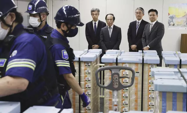Bank of Japan Governor Kazuo Ueda, center, looks on as new banknotes are being delivered, at the BOJ headquarters in Tokyo, Japan, Wednesday, July 3, 2024. (Japan Pool/Kyodo News via AP)