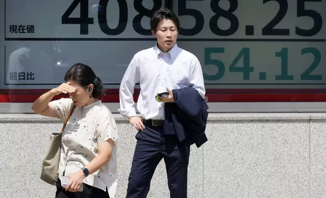 People stand in front of an electronic stock board showing Japan's Nikkei 225 index at a securities firm under the intense sun Monday, July 8, 2024, in Tokyo. (AP Photo/Eugene Hoshiko)