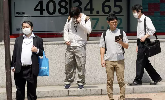 People stand in front of an electronic stock board showing Japan's Nikkei 225 index at a securities firm under the intense sun Monday, July 8, 2024, in Tokyo. (AP Photo/Eugene Hoshiko)