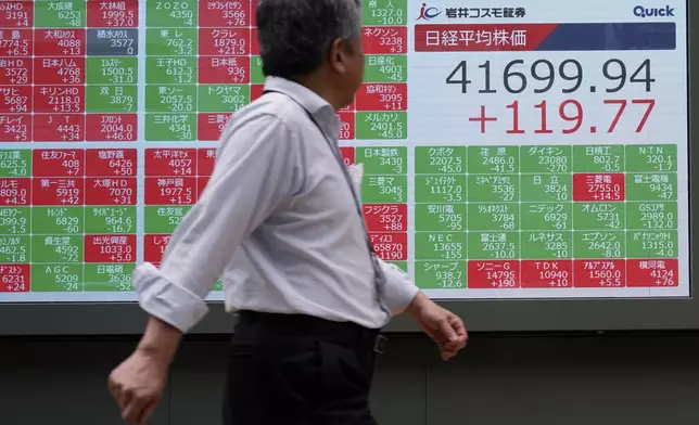 A person walk as he looks at an electronic stock board showing Japan's Nikkei index at a securities firm Wednesday, July 10, 2024, in Tokyo. (AP Photo/Eugene Hoshiko)