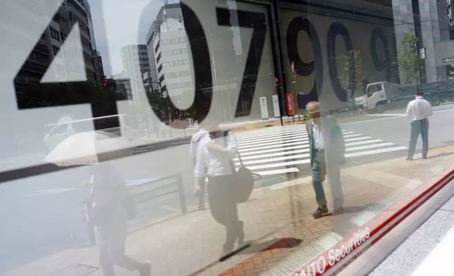 People are reflected on the window of an electronic stock board showing Japan's Nikkei 225 index at a securities firm Monday, July 8, 2024, in Tokyo. (AP Photo/Eugene Hoshiko)