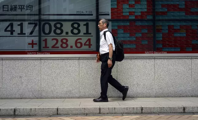 A person walks in front of an electronic stock board showing Japan's Nikkei index at a securities firm Wednesday, July 10, 2024, in Tokyo. (AP Photo/Eugene Hoshiko)