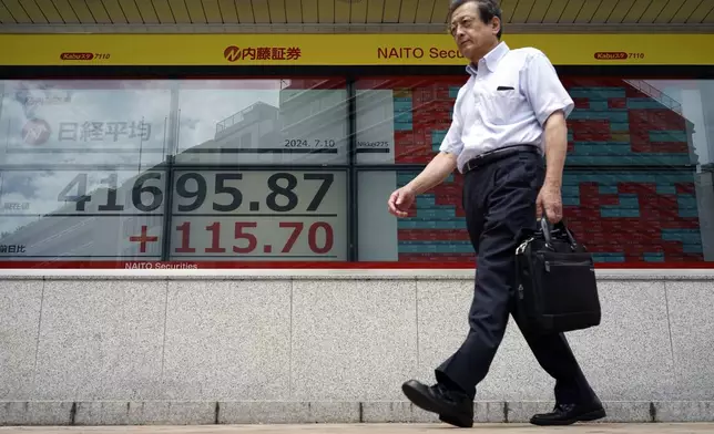 A person walks in front of an electronic stock board showing Japan's Nikkei index at a securities firm Wednesday, July 10, 2024, in Tokyo. (AP Photo/Eugene Hoshiko)